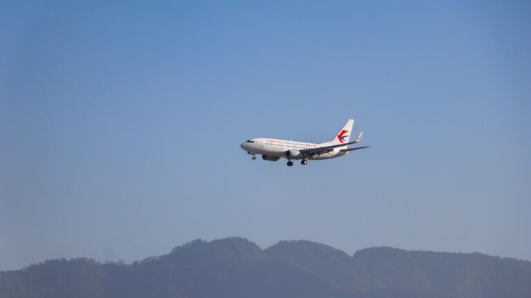 white and red passenger plane flying during daytime