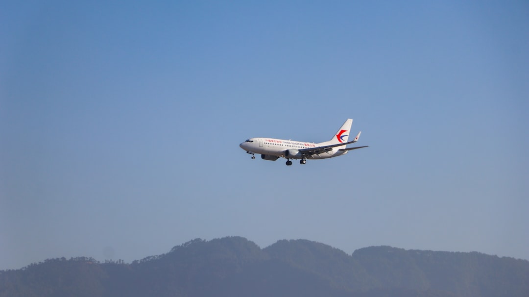 white and red passenger plane flying during daytime