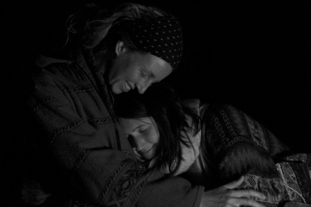 woman in black jacket kissing man in black jacket