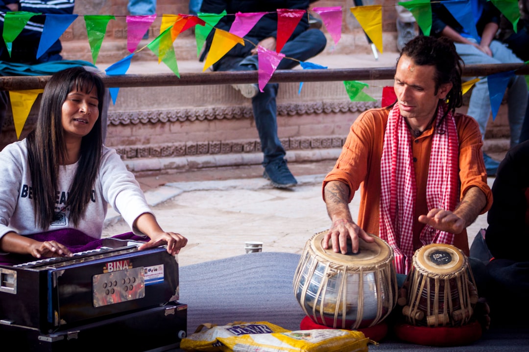 man in white long sleeve shirt playing drum