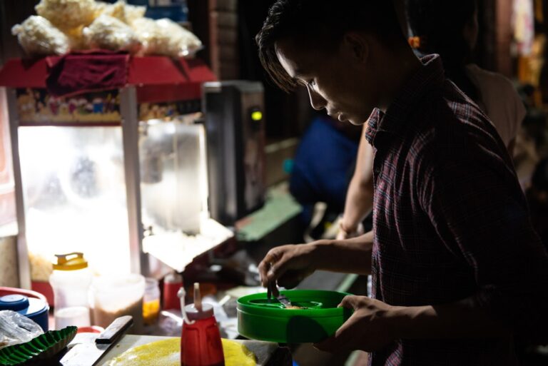 man in black shirt holding green plastic container