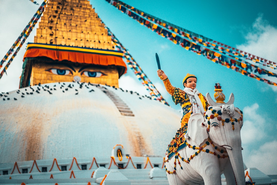 man in white and red traditional dress standing near white and gold temple during daytime