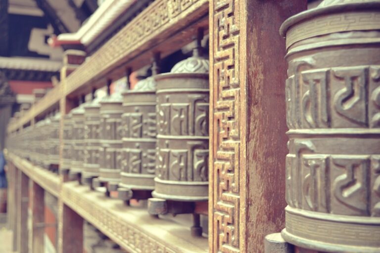 a row of metal bells sitting on top of a wall