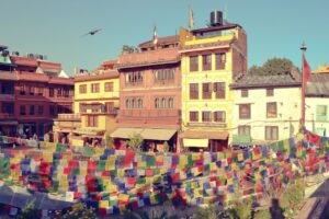 a bunch of colorful flags hanging in front of a building