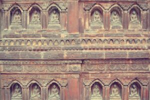 a stone wall with carvings of buddhas on it