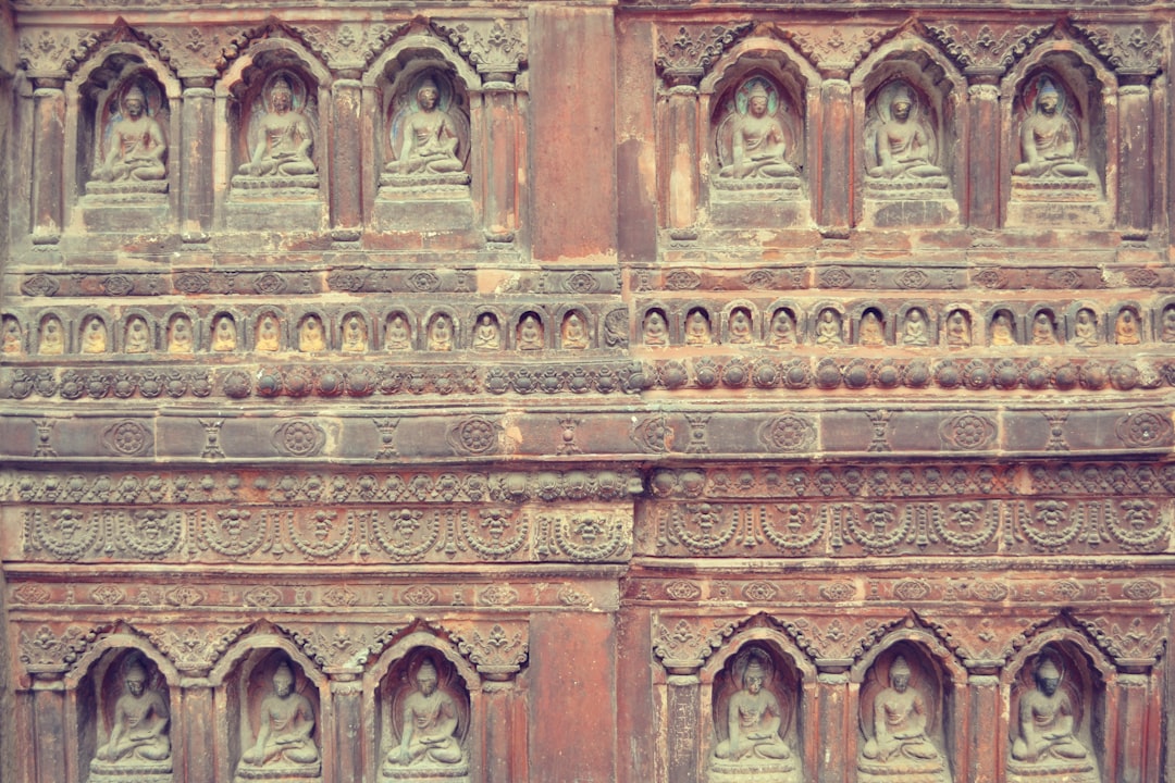 a stone wall with carvings of buddhas on it