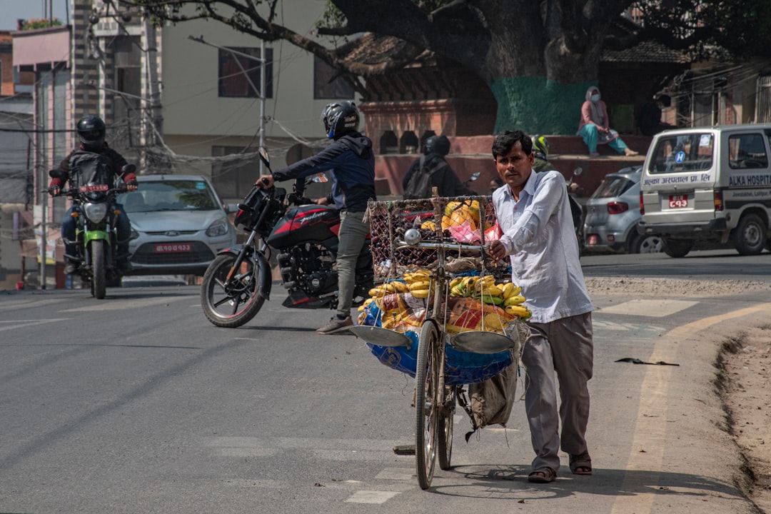 a person pushing a cart full of fruit on a street