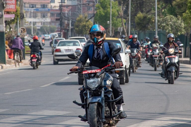 a group of people ride motorcycles down a street