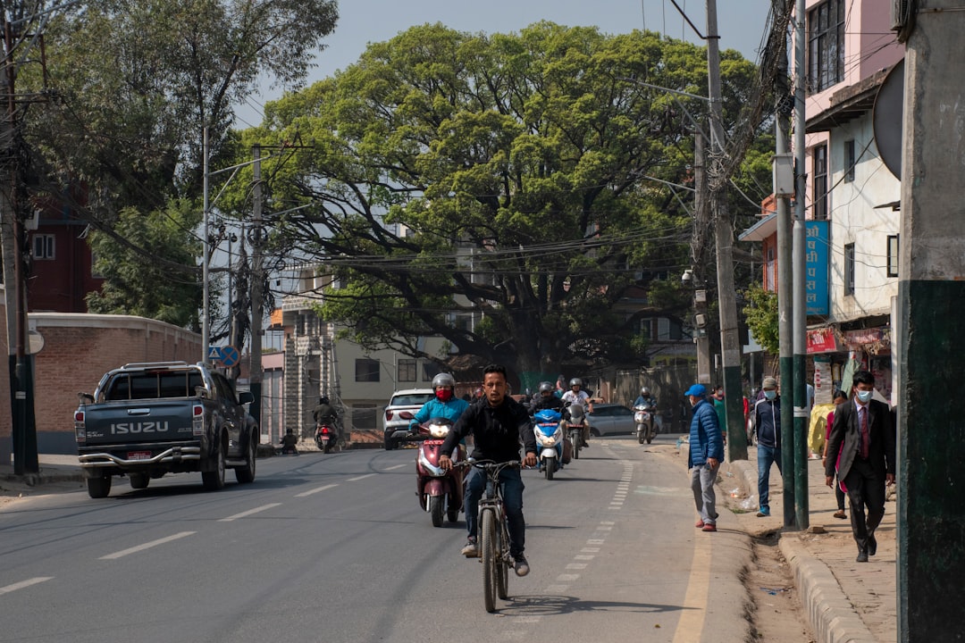 a group of people ride bikes down a street with La Rambla, Barcelona in the background