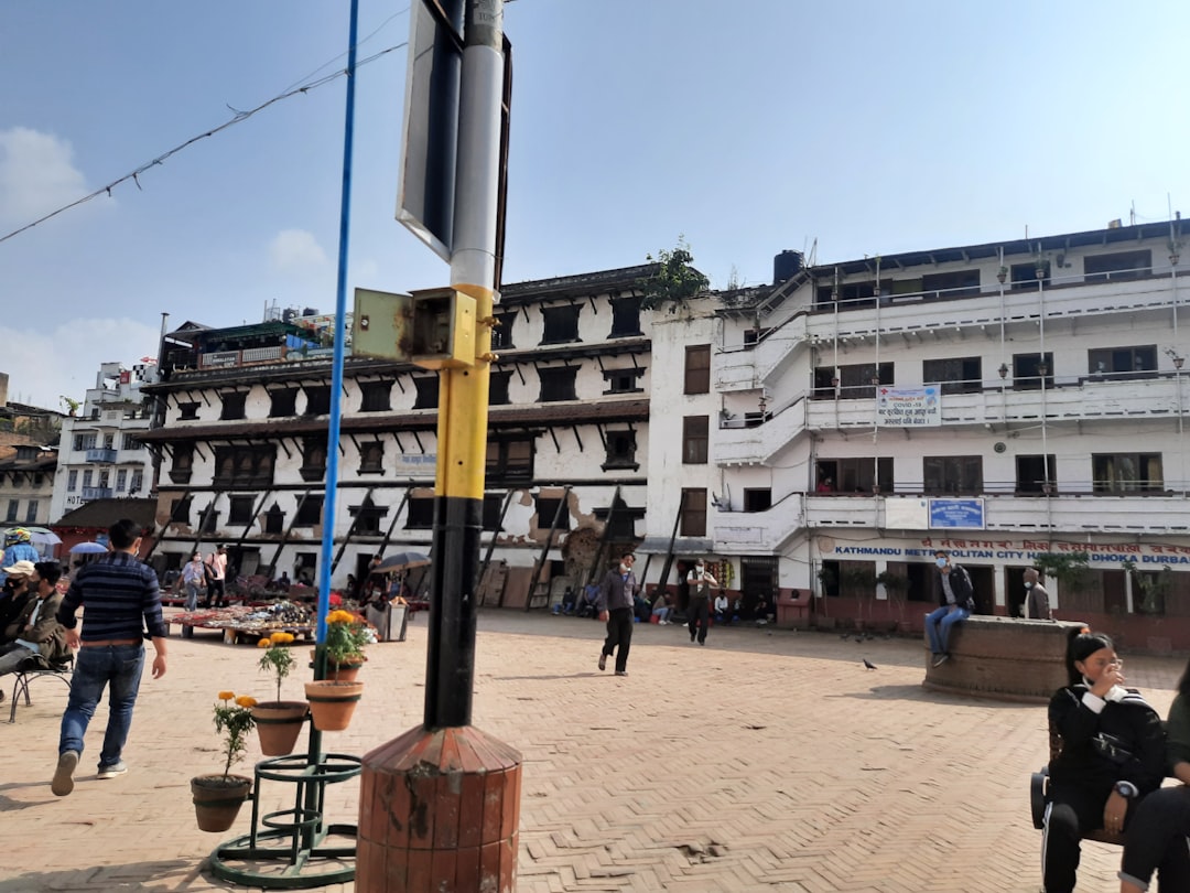 a group of people walking on a street next to a building