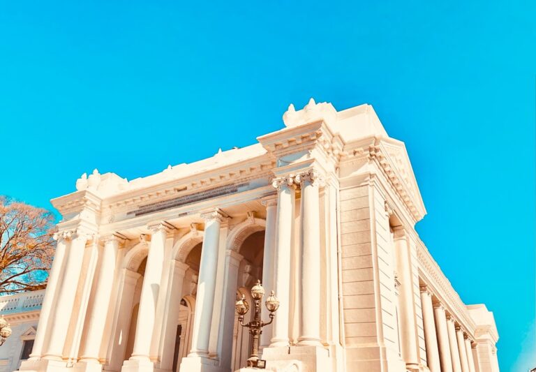 a large white building with a clock on the front of it