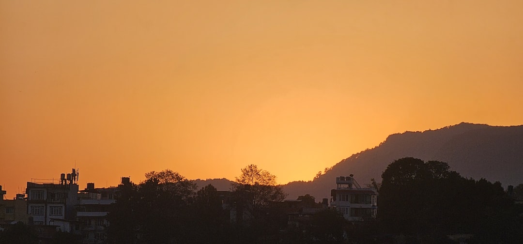 A plane flying over a city at sunset