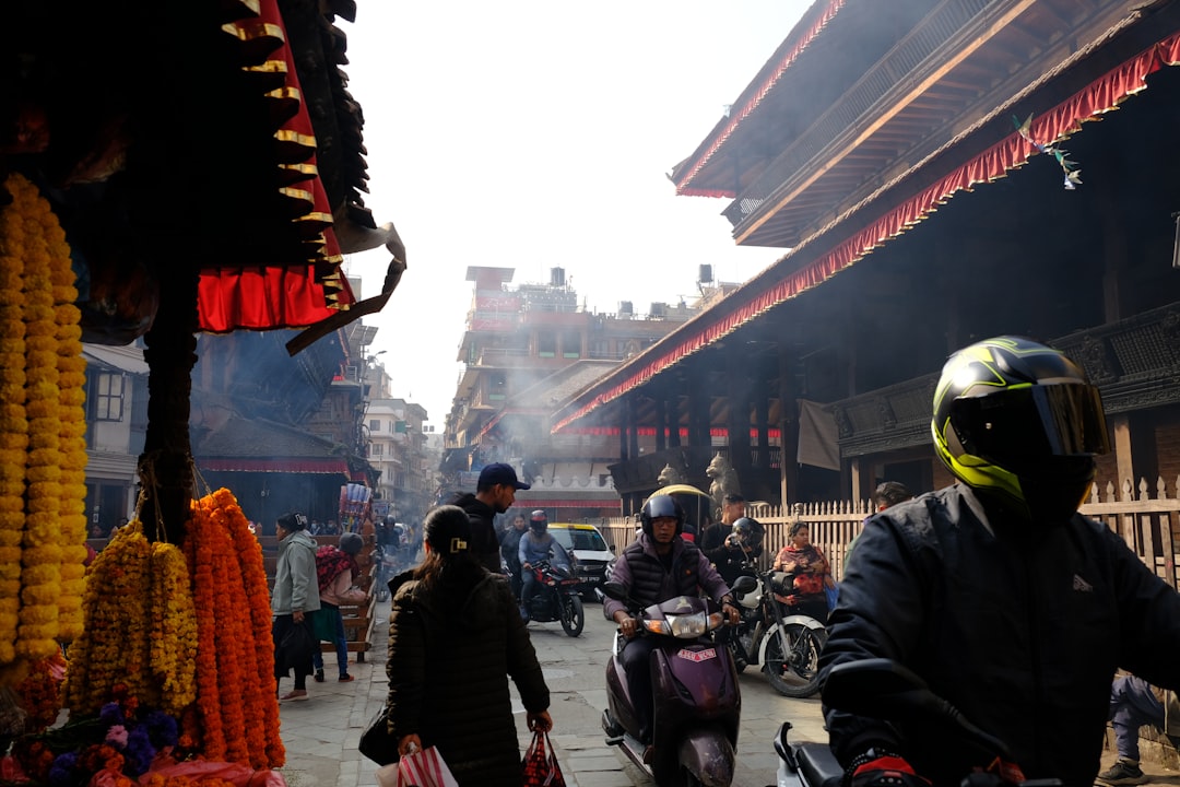 People and vehicles on a bustling street in nepal.