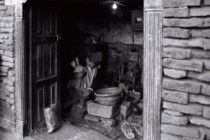 A darkened room shows a person working.