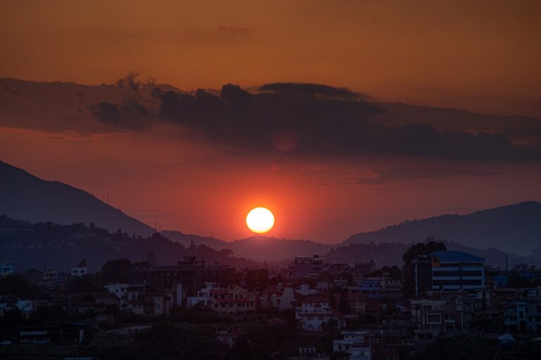 Sunset over distant hills and a small town.