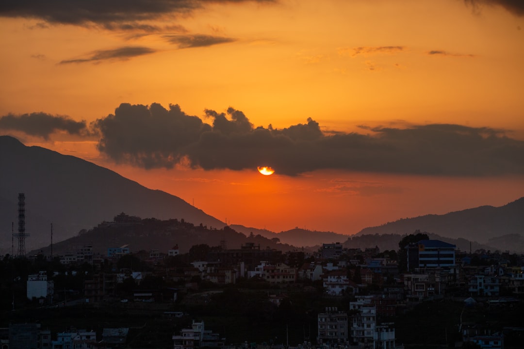 Golden sunset over distant mountains and city lights