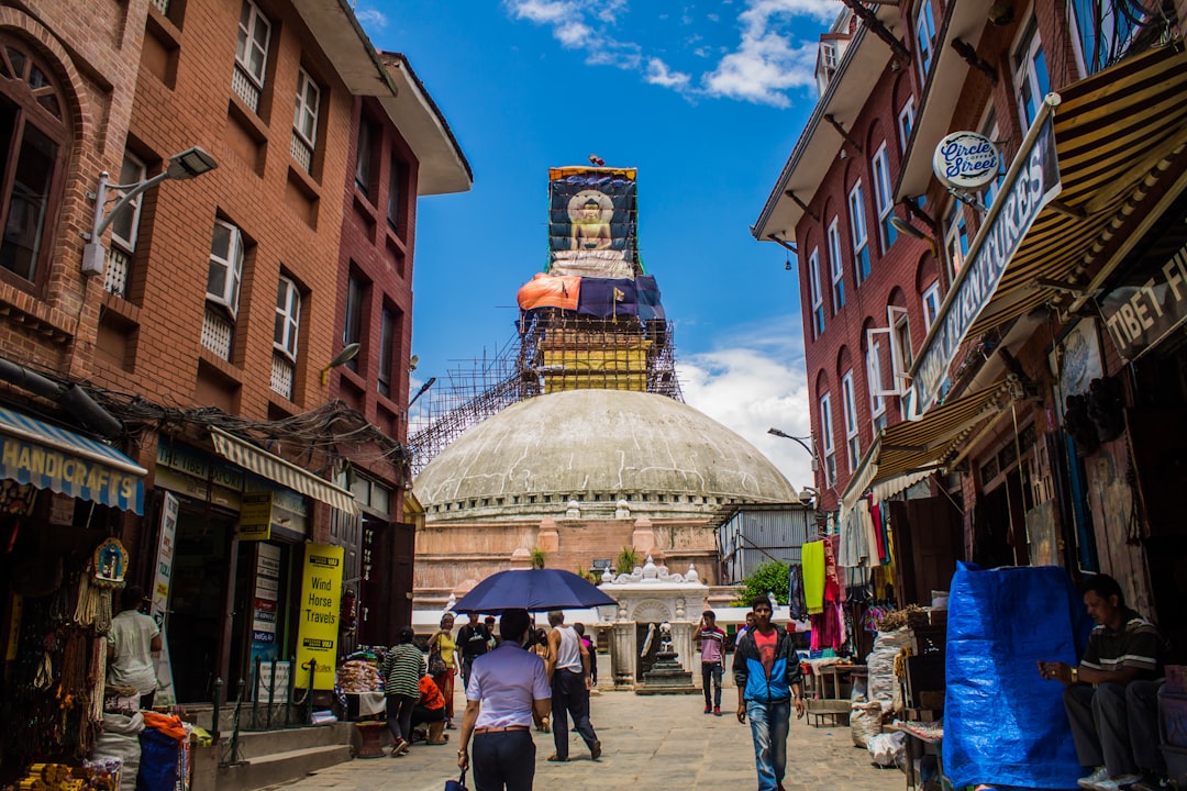 Street view leading to a large stupa with buildings.