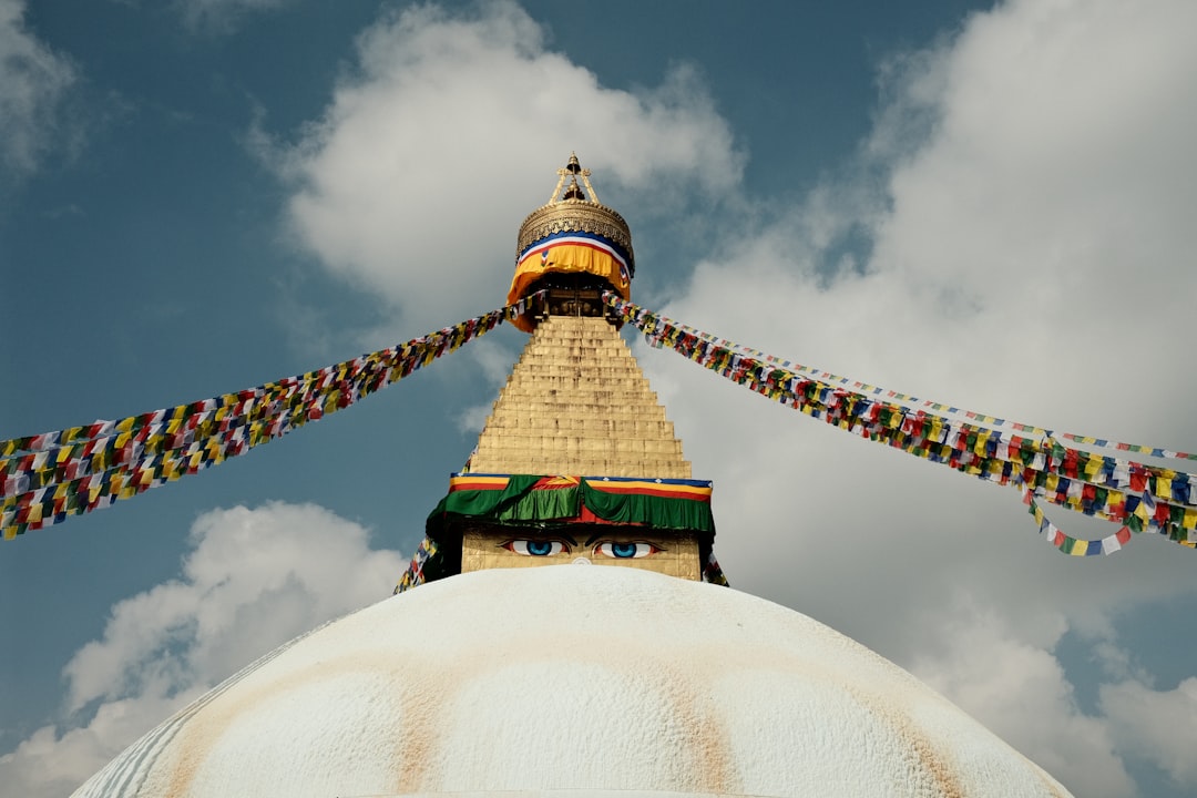 Buddhist stupa with prayer flags against cloudy sky